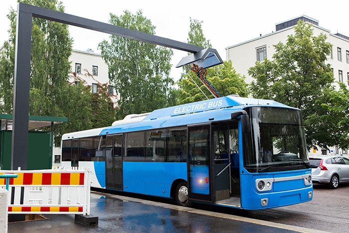 Electric bus at a stop being opportunity charged using wireless induction charging